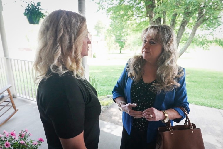 Becky Tennant (left) and Laura Kimble talk outside on their front porch.